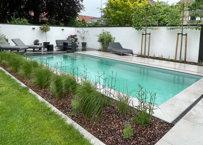 Naturpool mit Gräsern und Keramikfliesen gestaltet